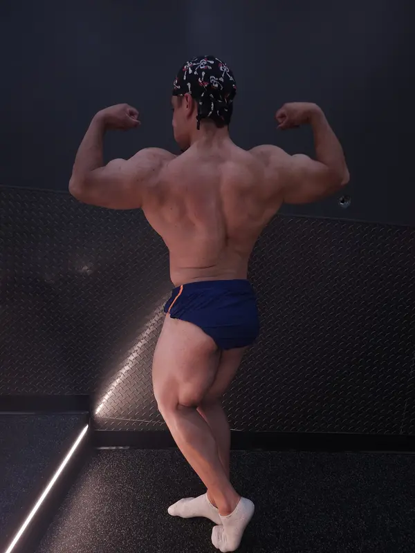 Cris Coach pose doble biceps de espalda